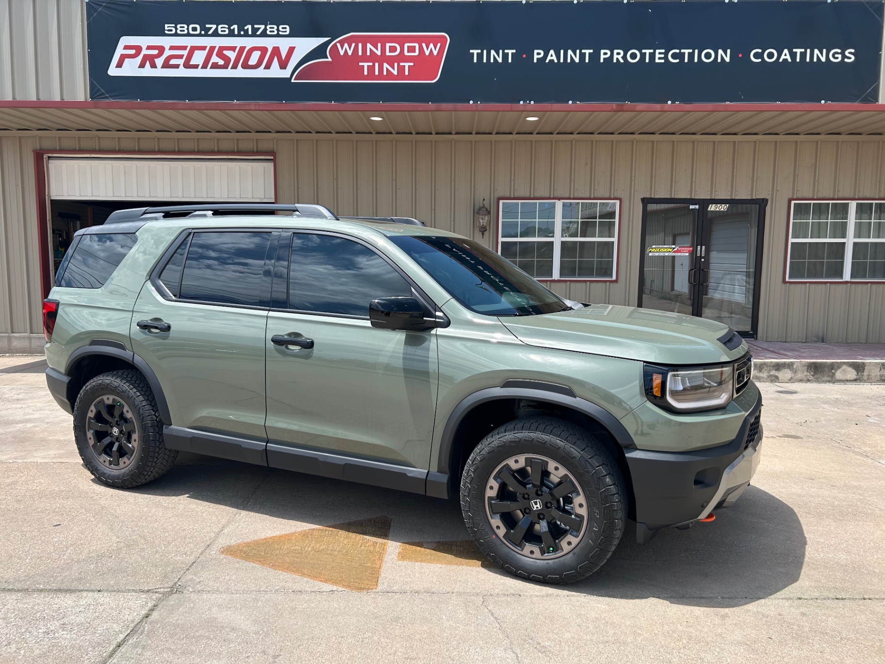 Green Honda Passport TrailSport with window tint installed at Precision Window Tint