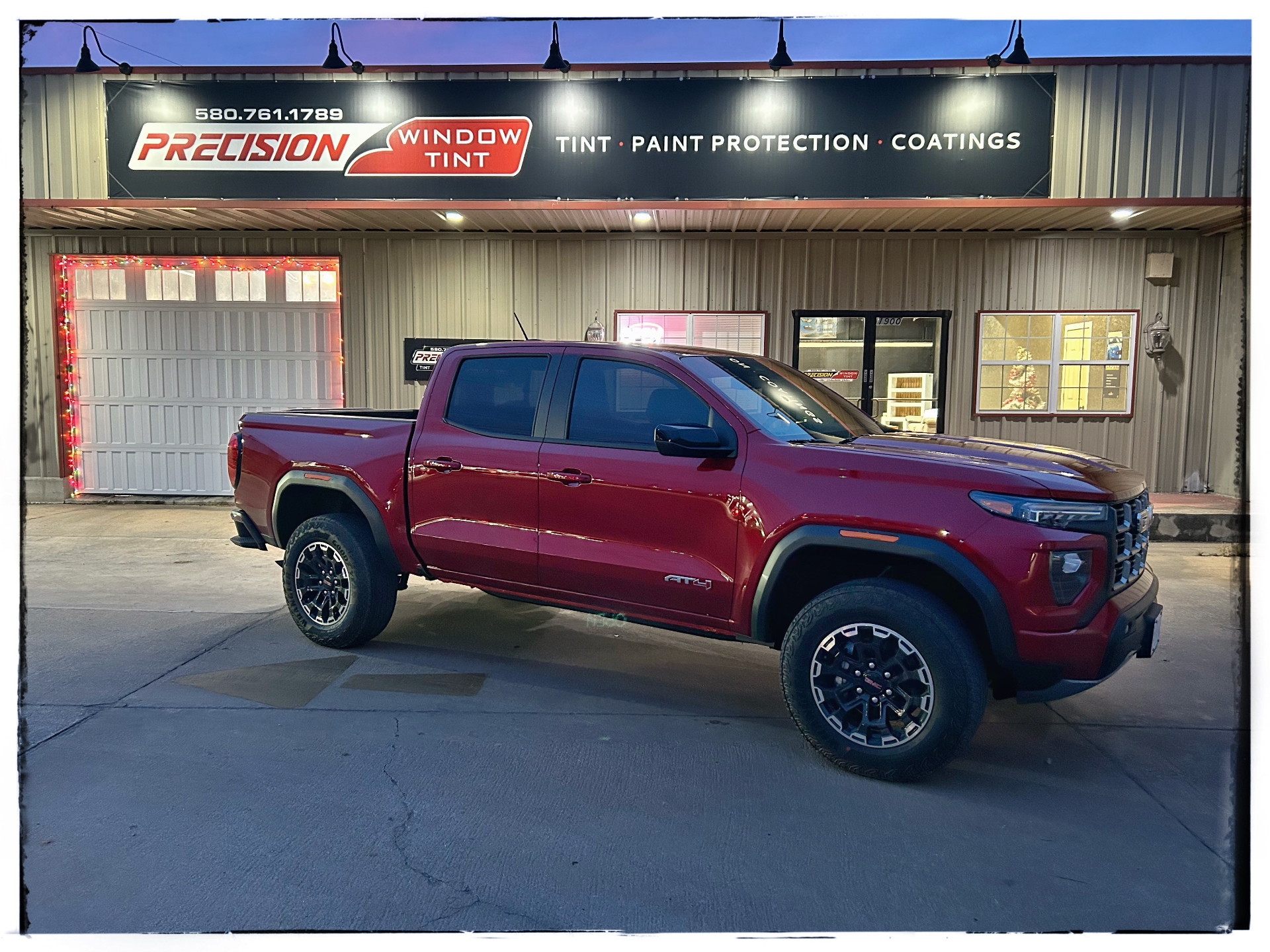 Installer applying window film to a truck door glass inside the Precision Window Tint shop in Ponca City